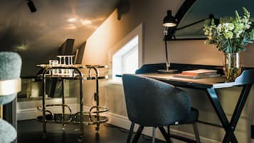 A modern kitchen with a dining table, a bar cart, and a chair.
