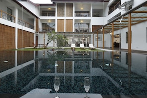 Una piscina al aire libre, sillones reclinables de piscina