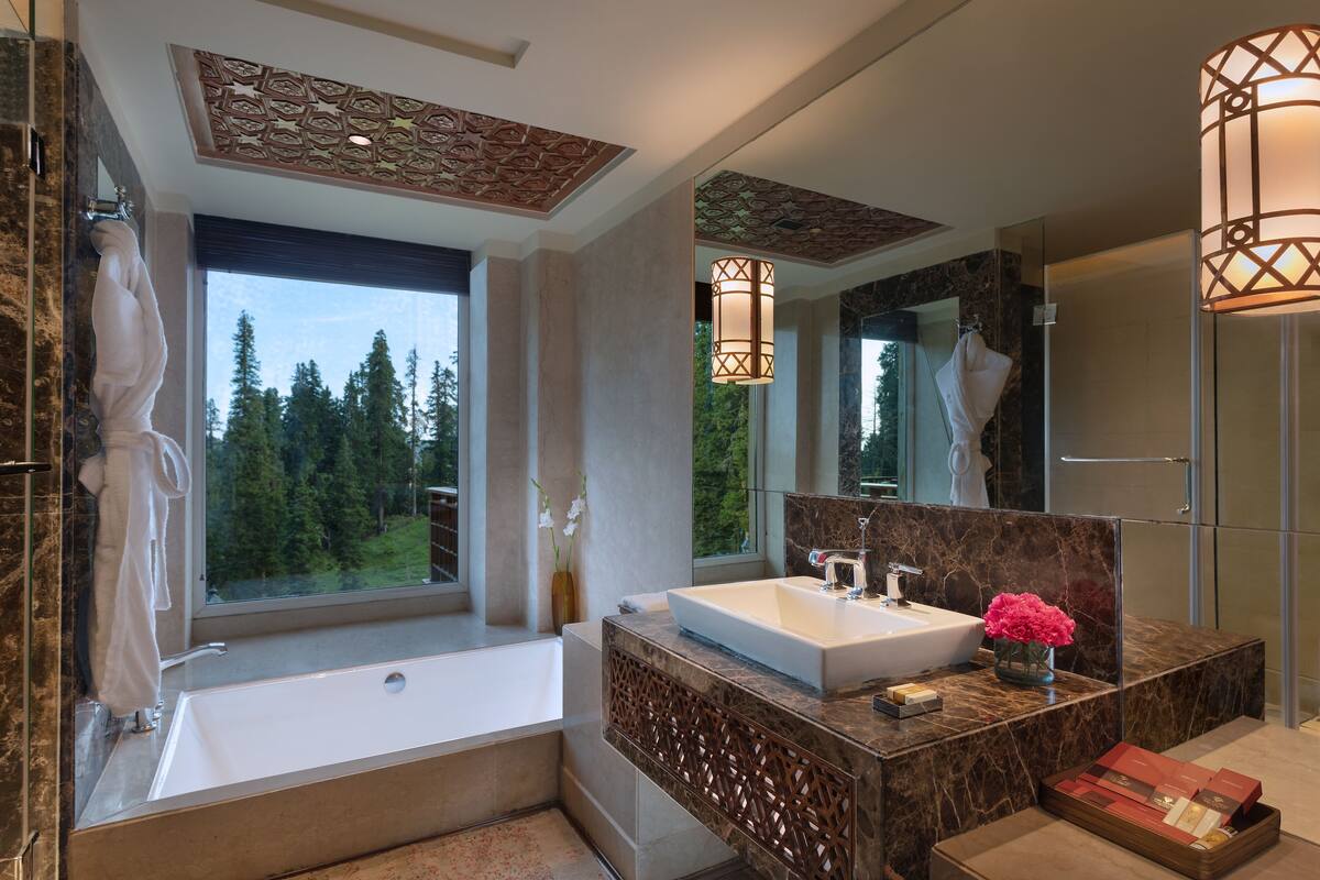 A modern bathroom with a large bathtub, a white sink, and a large mirror.