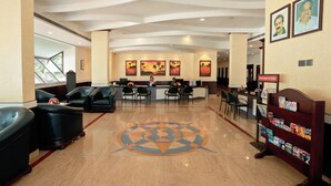 Vestíbulo de hotel con mostrador de recepción, zona de estar y un diseño decorativo en el suelo.