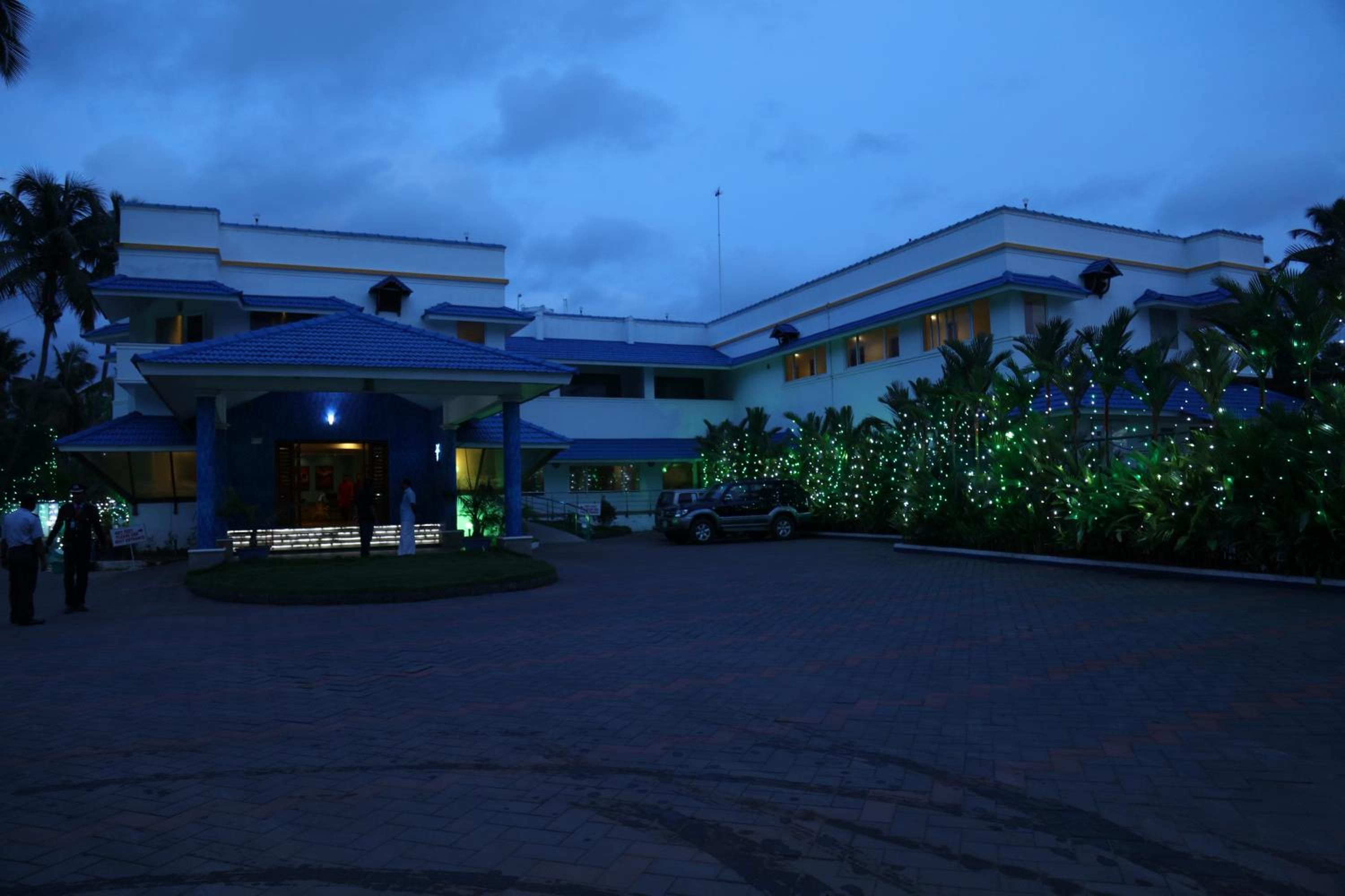A multi-story hotel with a covered entrance and a parking area.