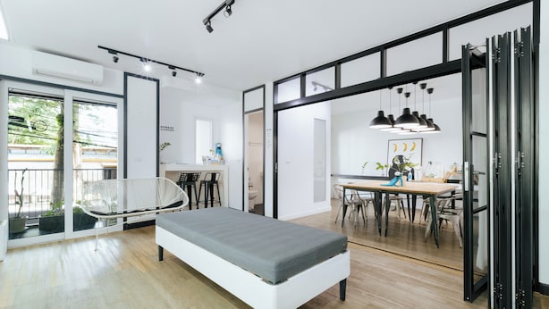 A modern room with a bed, a dining area, and a large window. - Blu Monkey Bed & Breakfast Phuket (Phuket)