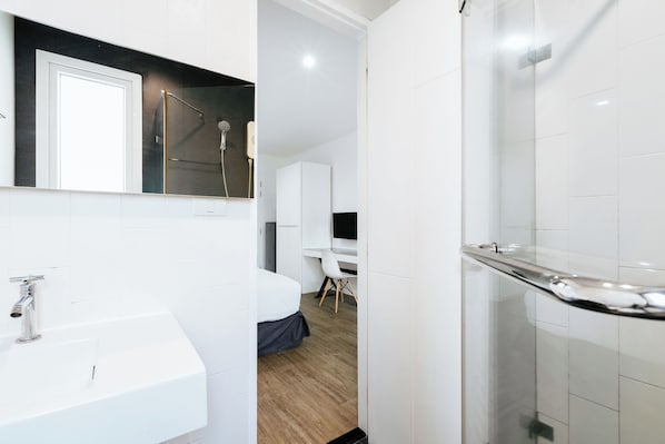 A modern bathroom with a white sink, a glass shower enclosure, and a wooden floor. - Blu Monkey Boutique Samkong Phuket (Phuket)