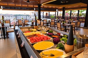 Buffet com diversos pratos e vista da cidade ao fundo.
