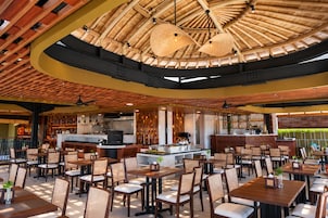 Un ristorante con un bancone centrale, posti a sedere all'aperto e un soffitto in bambù.