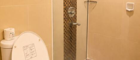 A bathroom with a toilet, a glass shower enclosure, and a towel rack.