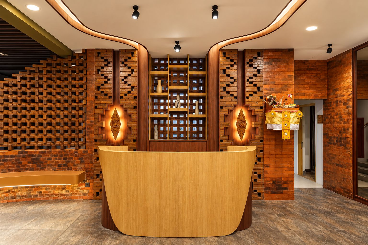 A reception desk with a wooden finish, flanked by brick-patterned walls and recessed lighting.