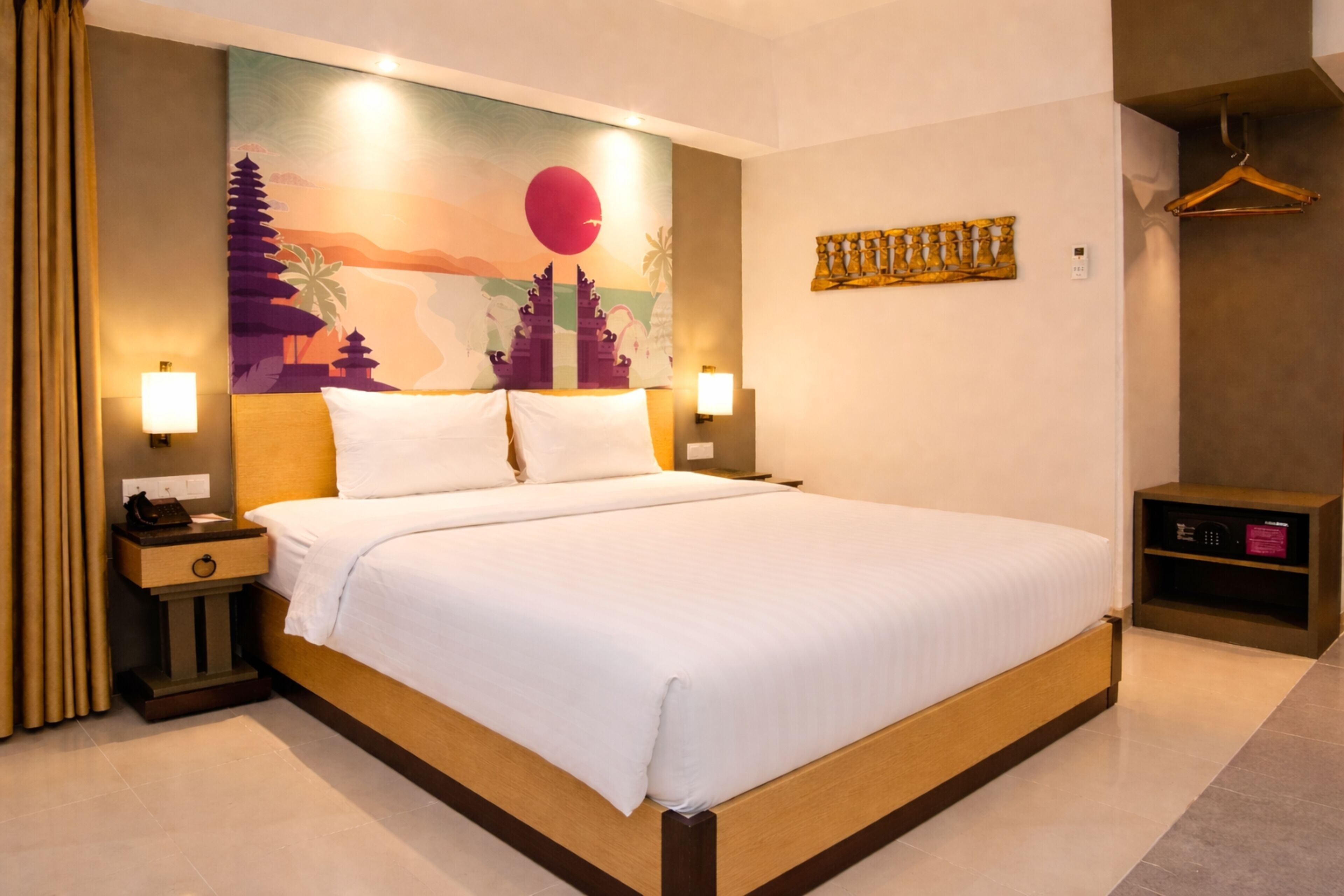 Habitación de hotel con una cama grande, mesitas de noche, un perchero de pared, un cuadro colgado y un estante pequeño.