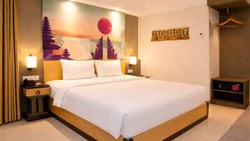 Habitación de hotel con una cama grande, mesitas de noche, un perchero de pared, un cuadro colgado y un estante pequeño.