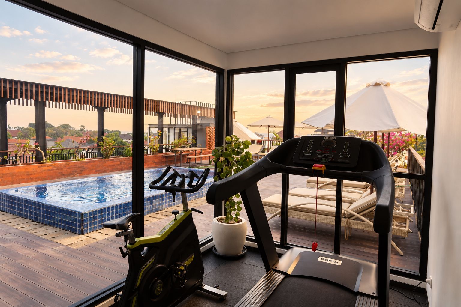 Ein Zimmer mit Laufband, kleinem Pool und Blick auf eine Brücke und einen Strand.