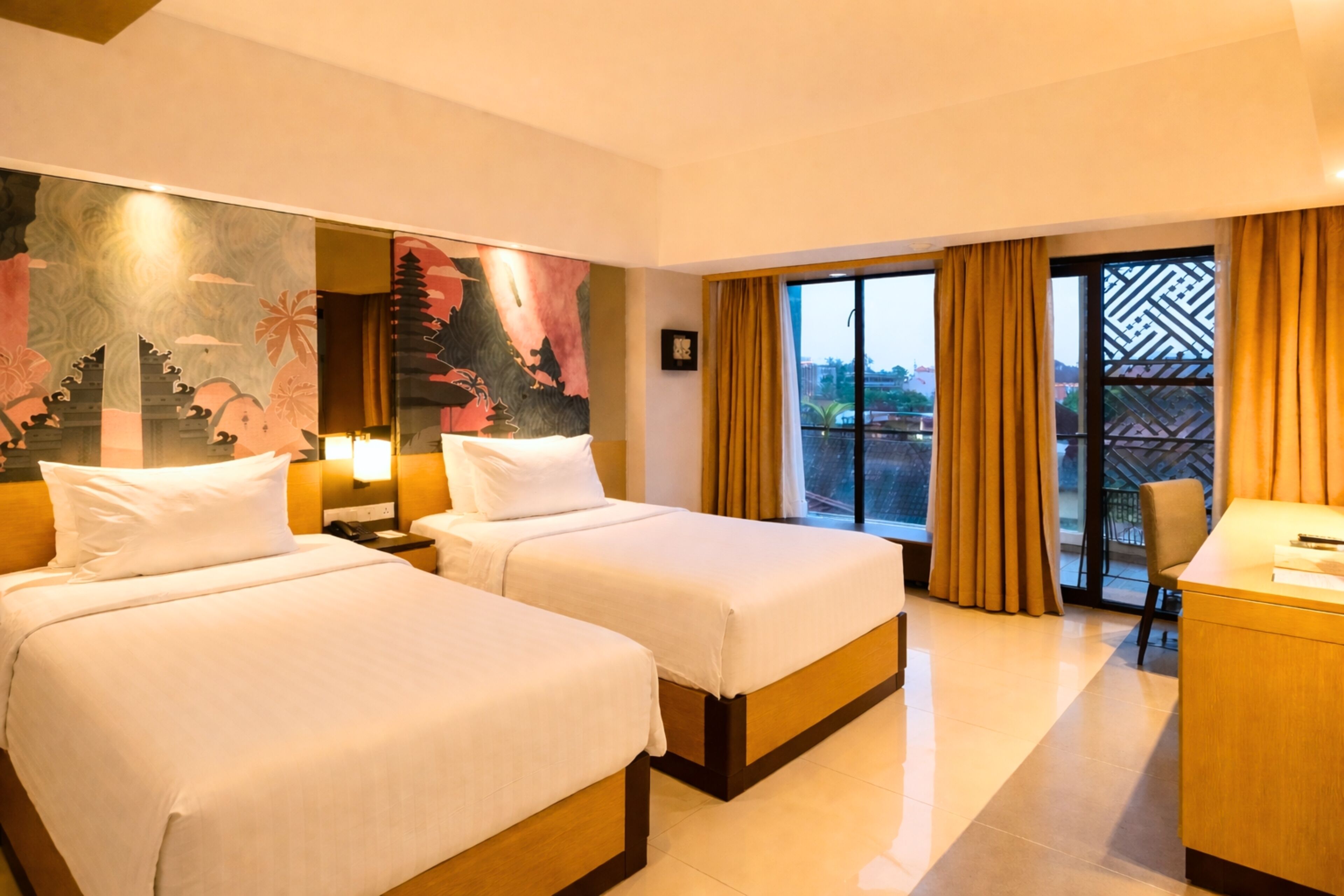 A hotel room with two beds, a desk, and a large window with curtains.