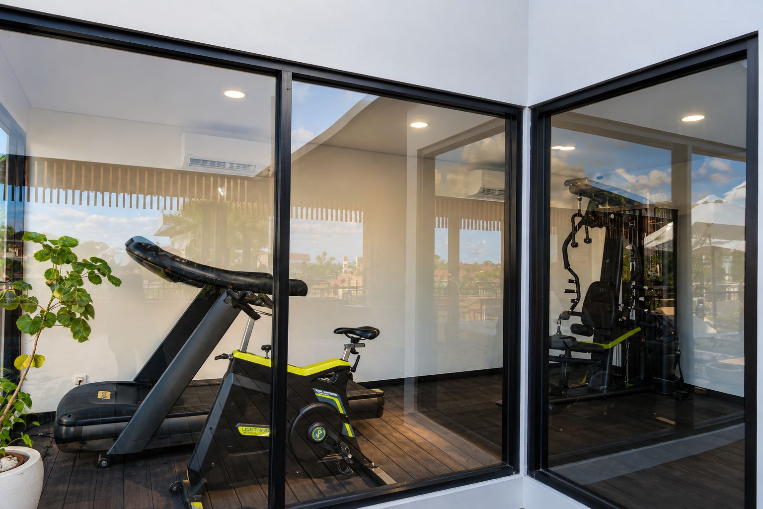 A modern home gym with a treadmill, stationary bike, and weight equipment.
