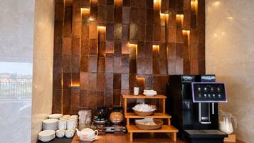 A breakfast setup with a coffee machine, tea options, and a milk dispenser.