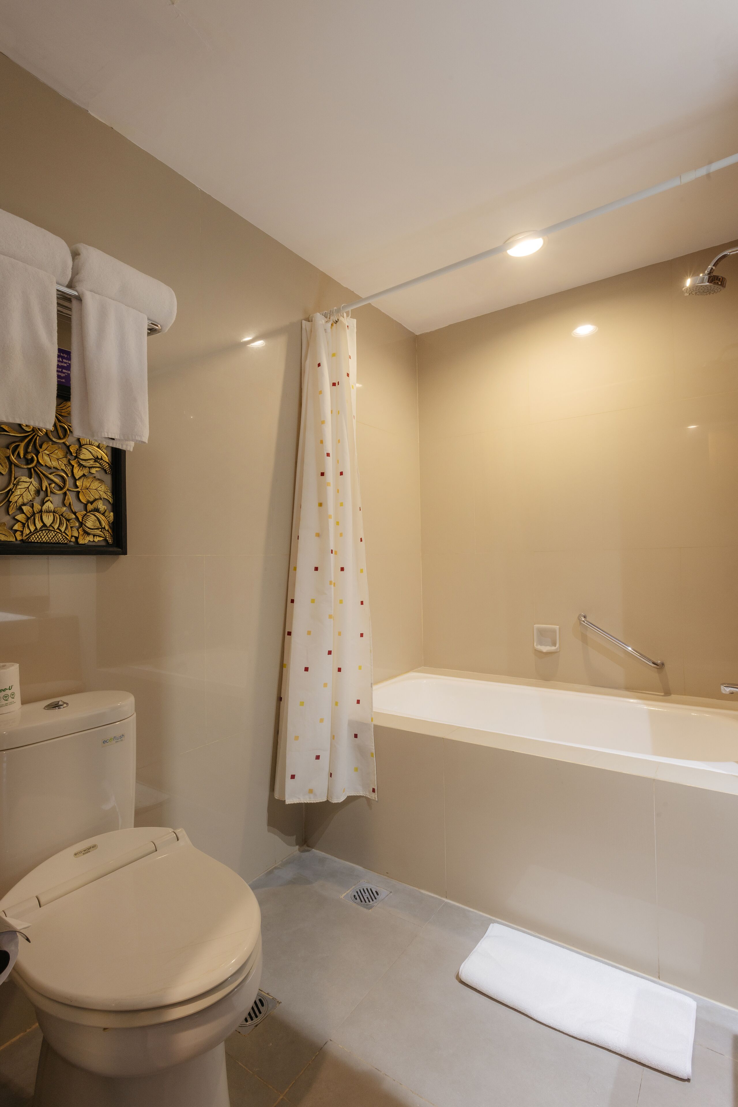 A bathroom with a toilet, a shower curtain, and a bathtub.