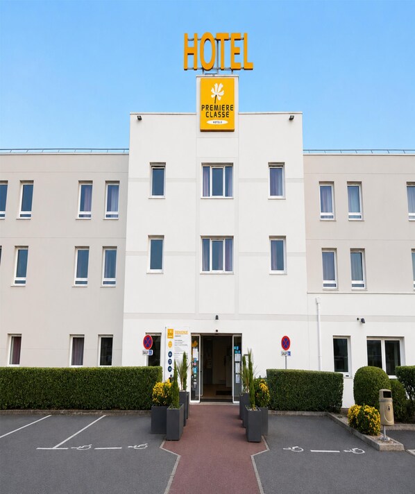 A hotel building with a sign reading 'HOTEL PREMIERE CLASSE HOTELS.' - Hôtel Première Classe Caen Nord - Mémorial (Saint-Contest)