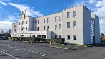 Un hotel modern amb façana plana, nombroses finestres i un rètol que indica que és un hotel.