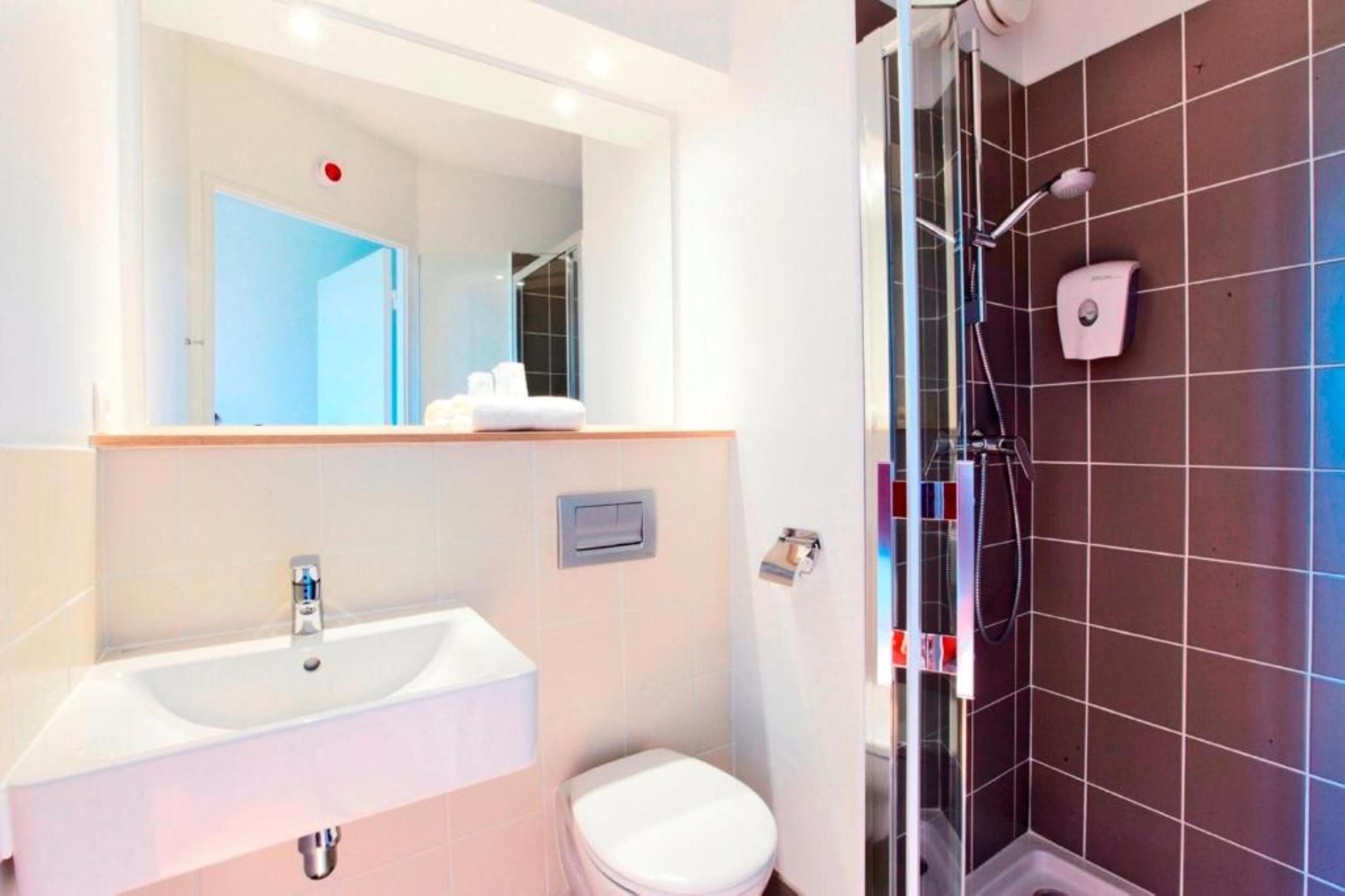 A bathroom with a sink, toilet, and shower.