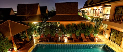 Una piscina al aire libre, tumbonas