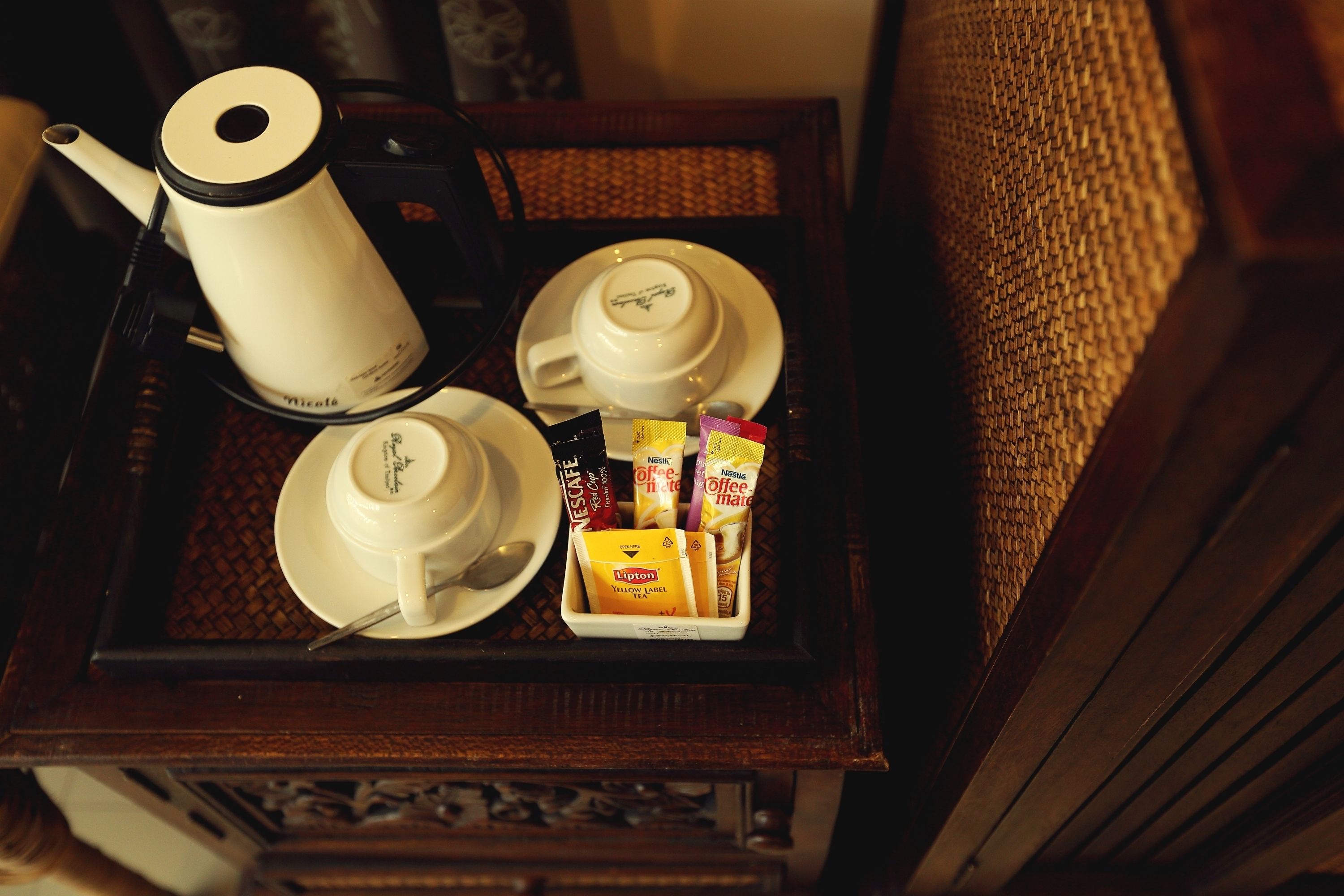 Un plateau avec une machine à café, des tasses et des dosettes de café.