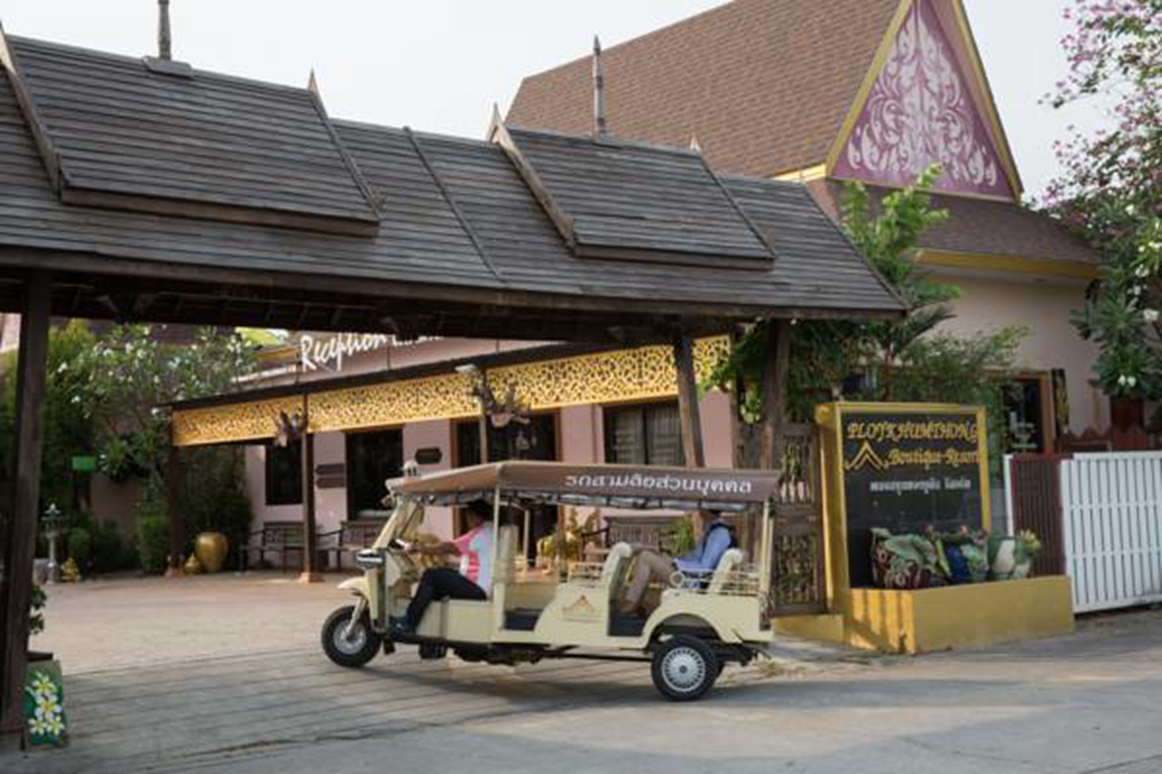 A tuk-tuk parked in front of a building with a sign that reads "Ploy Khemaphong".