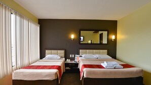 A hotel room with two beds, a nightstand, a mirror, and a window with blinds. - Express Inn - Cebu Hotel (Cebu City)