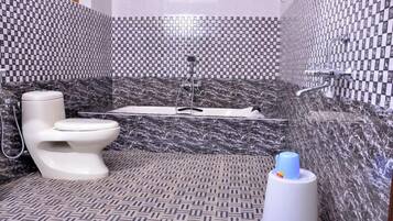 A bathroom with a toilet, a bathtub, and a shower.