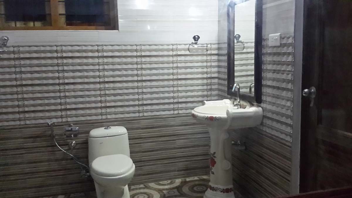 A bathroom with a toilet, sink, and mirror.