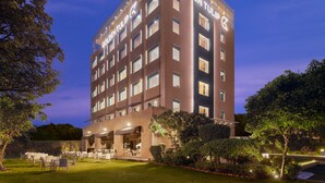 A multi-story hotel with a prominent "Golden Tulip" sign, outdoor seating area, and well-maintained landscaping. - Golden Tulip Gurgaon - Sector 29 (Gurugram)