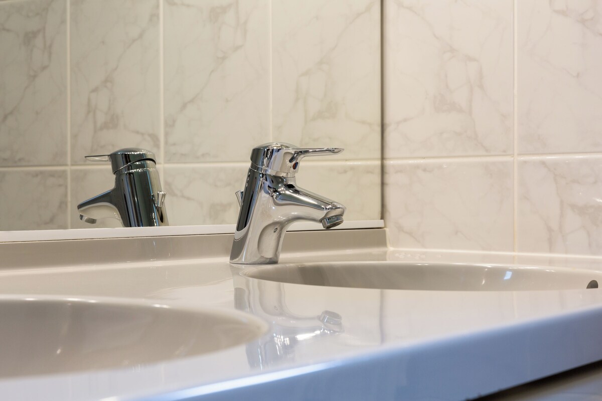 Un baño con dos lavamanos y un espejo.