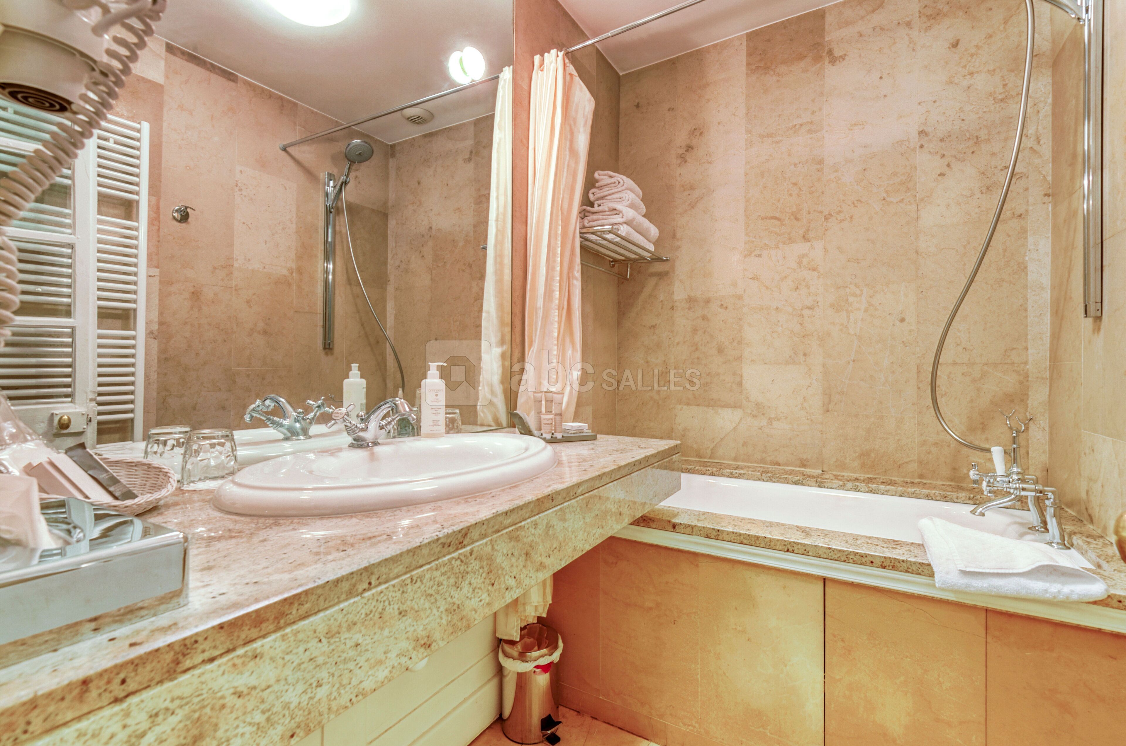 A bathroom with a sink, mirror, shower, and bathtub.