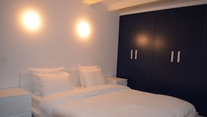 A bedroom with a large bed, two bedside tables, and a dark wardrobe. - Rembrandtplein B&B (Amsterdam)