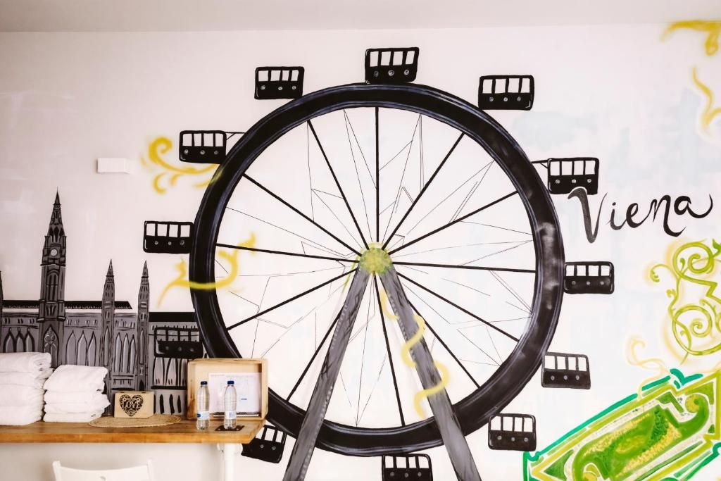 Eine Wand mit einem großen Fahrrad-Design, einer Uhr und einem kleinen Tisch mit Handtüchern und einem herzförmigen Gegenstand.