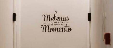 Un pasillo con un radiador y una frase motivacional en la pared.