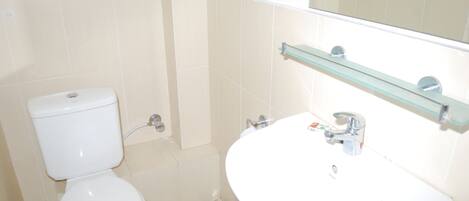 Ein Badezimmer mit Toilette, Waschbecken und Spiegel.
