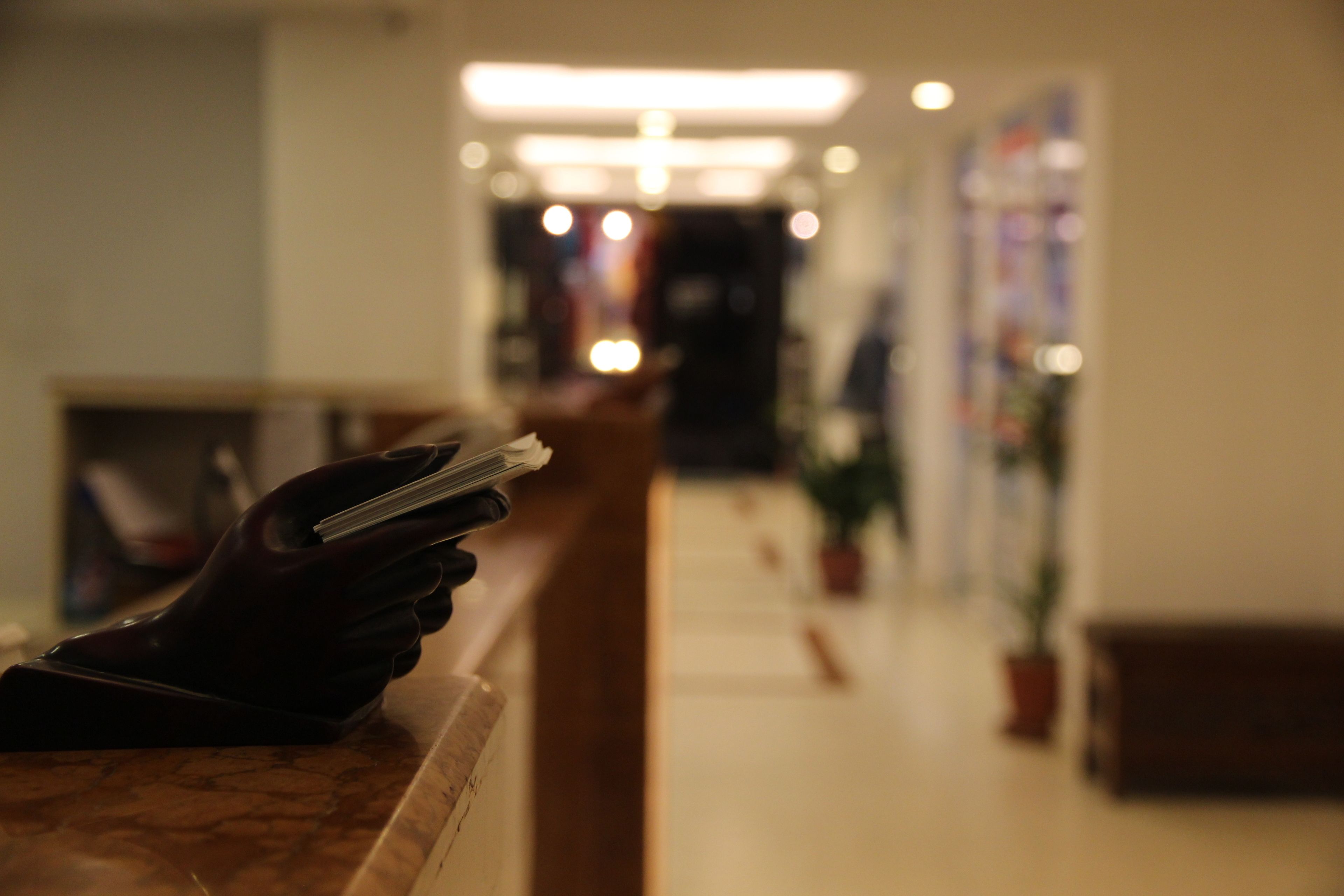 Una mano sosteniendo un teléfono inteligente en la recepción de un hotel.
