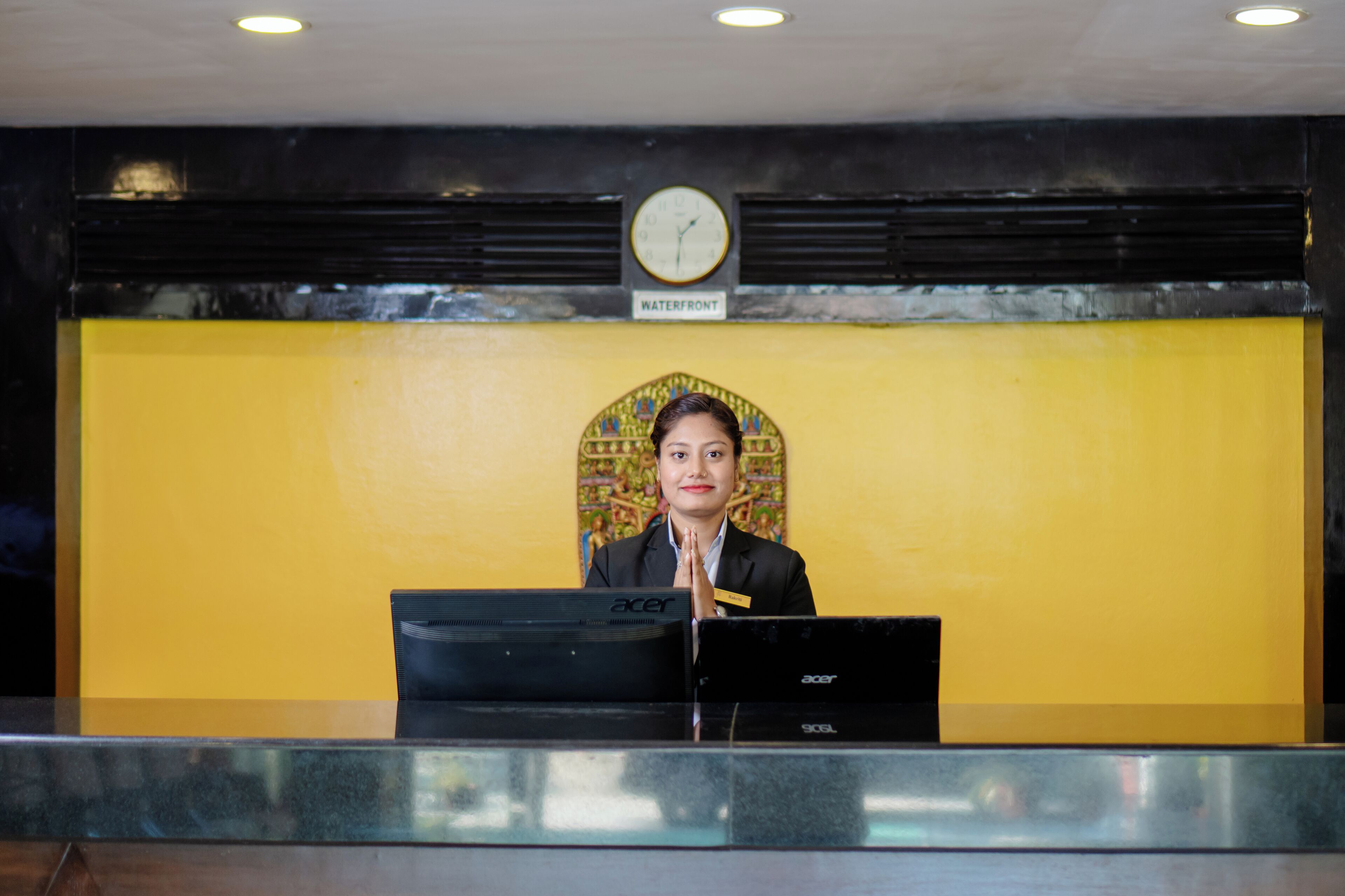 A reception desk with a clock above it and a sign that reads "Waterfront".