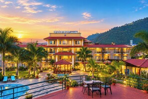 A resort with a swimming pool, outdoor seating, and a view of a hill. - Waterfront Resort by KGH Group (Pokhara)
