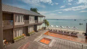 A hotel with a wooden deck, a swimming pool, and a view of the sea. - Baan Ploy Sea (Rayong)
