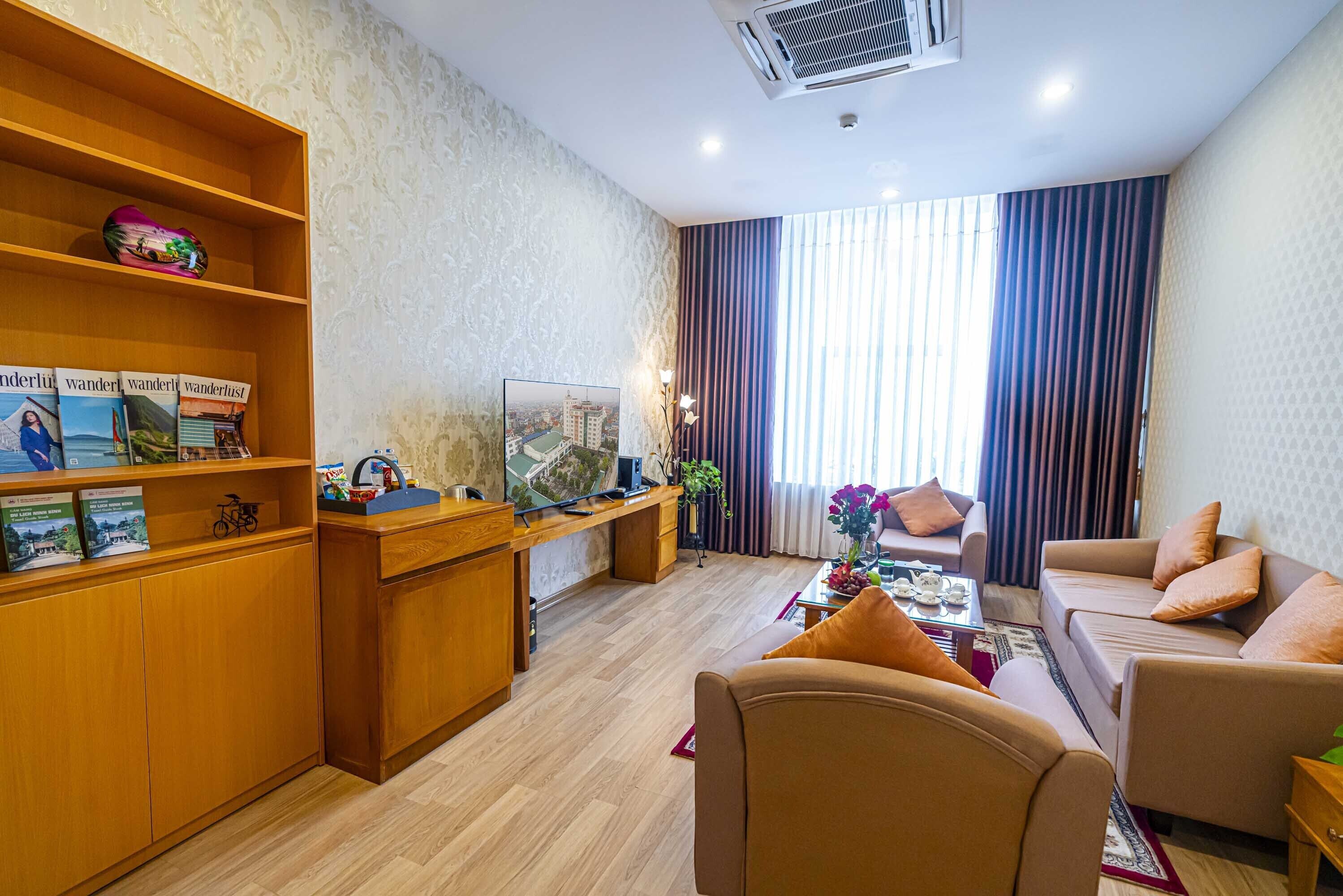 A modern living room with a wooden desk, a sofa, and a television.
