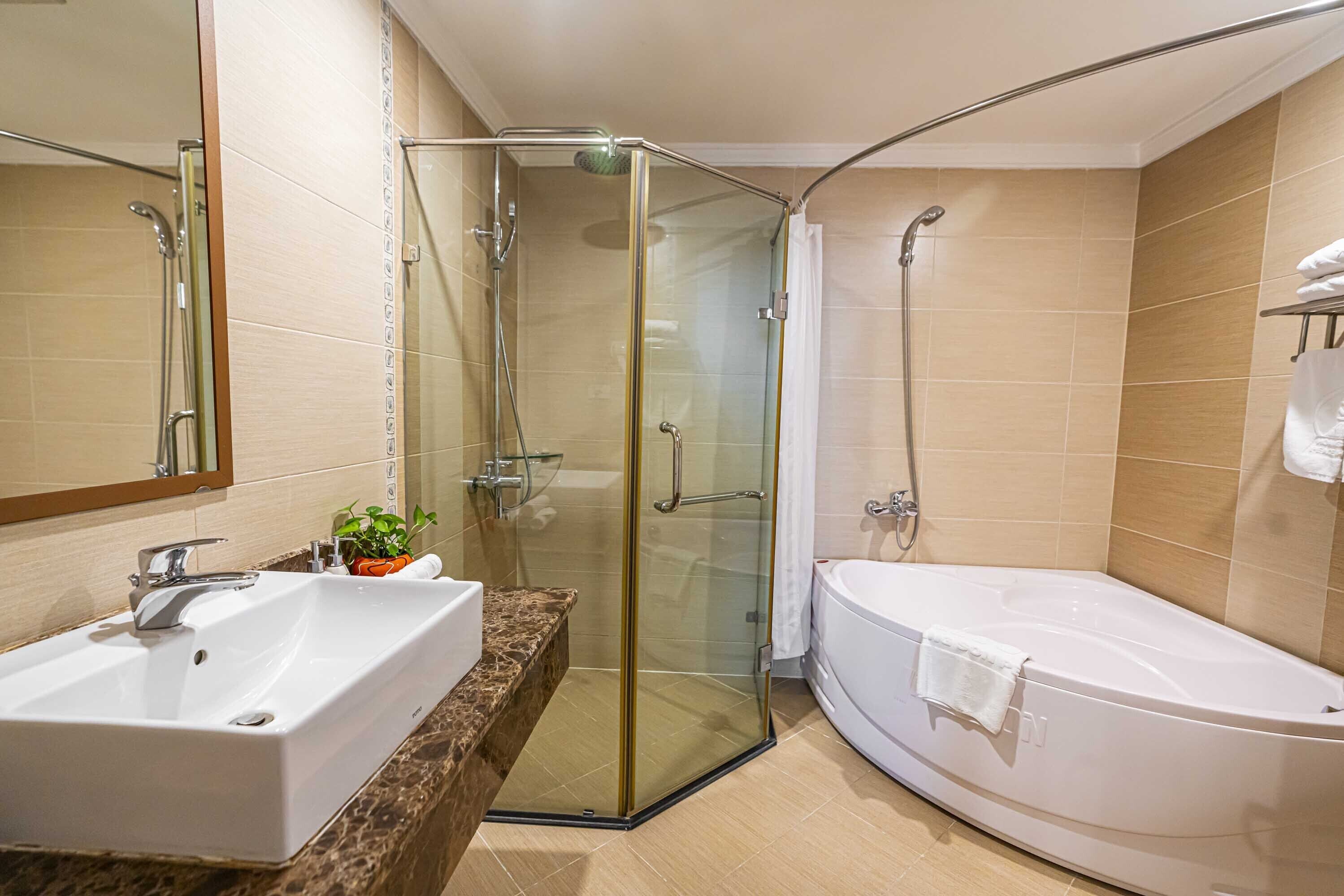 A modern bathroom with a glass-enclosed shower, a white sink, and a freestanding bathtub.