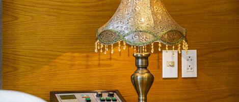 A lamp with a patterned lampshade and a control panel on a wooden surface.
