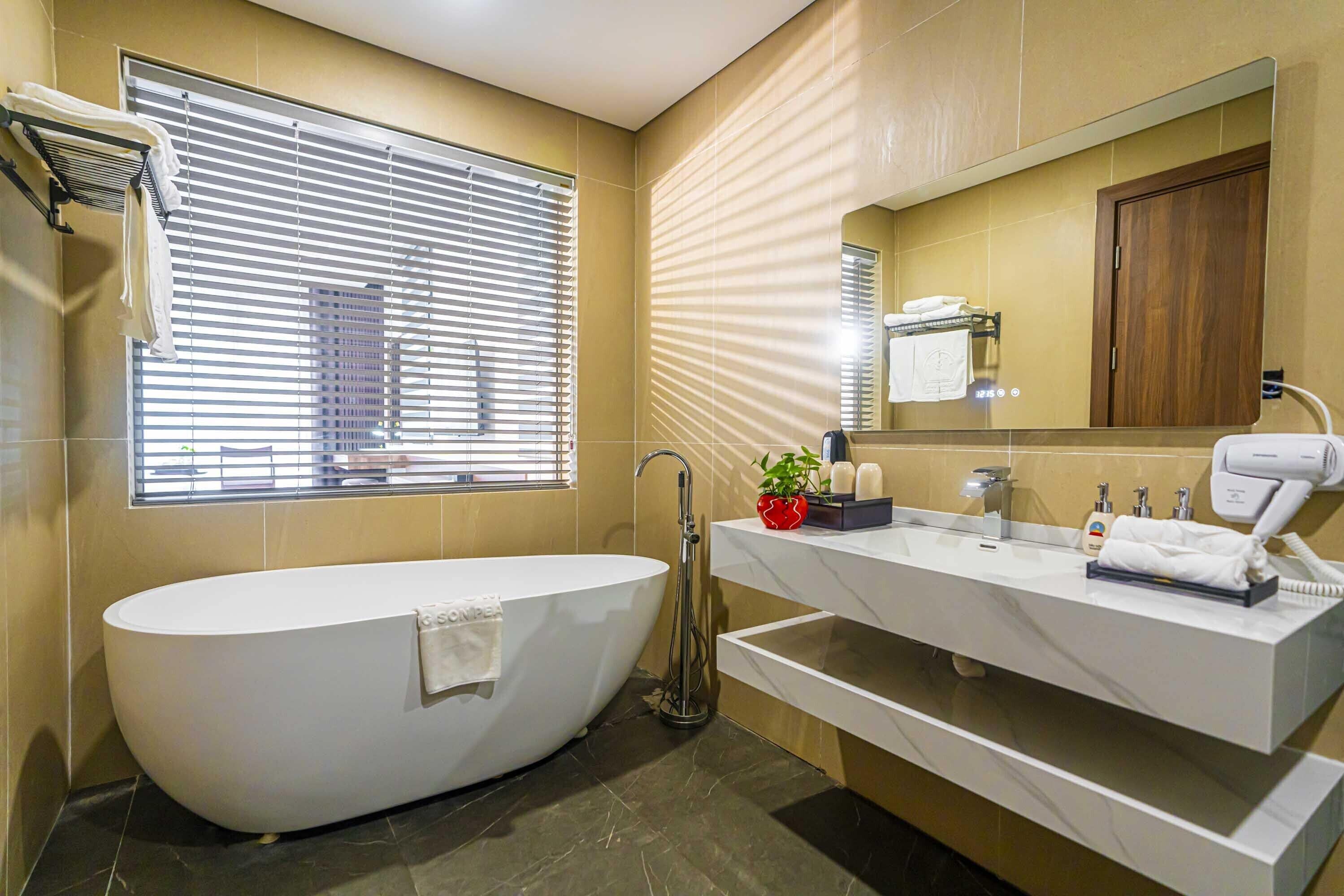 Un bagno moderno con una vasca freestanding, un mobile lavabo con specchio e una finestra con persiane.