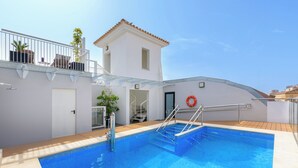 A swimming pool with a glass balustrade, a lifebuoy, and a small building with a tiled roof. - Dorma Málaga Museos (Málaga)
