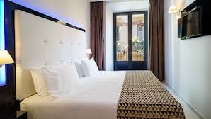 A hotel room with a large bed, a flat-screen TV, a nightstand, and a view of the outside balcony. - Dorma Málaga Museos (Málaga)