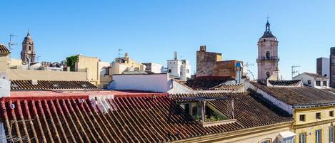 Vista de un paisaje urbano con edificios, una destacada torre del reloj y un cielo azul despejado.