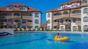Relax by the pool surrounded by comfortable lounge chairs and umbrellas.