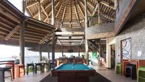 A pool table in a spacious indoor area with a high ceiling and wooden beams. - The Bellevue Resort (Panglao)