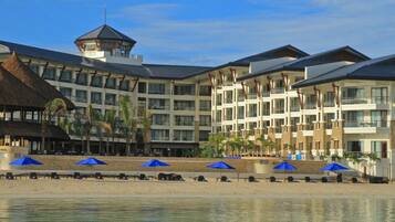En la playa, arena blanca, sillas reclinables de playa, sombrillas