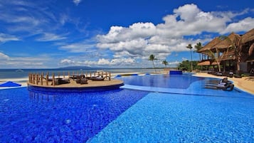 Una piscina al aire libre, sillones reclinables de piscina