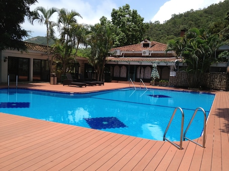 Una piscina al aire libre de temporada, sombrillas